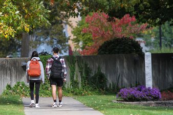 Two students walking toward Lightner Library wearing backpacks